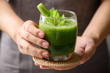 Celery green juice in glass holding by hand, Healthy drink for detox