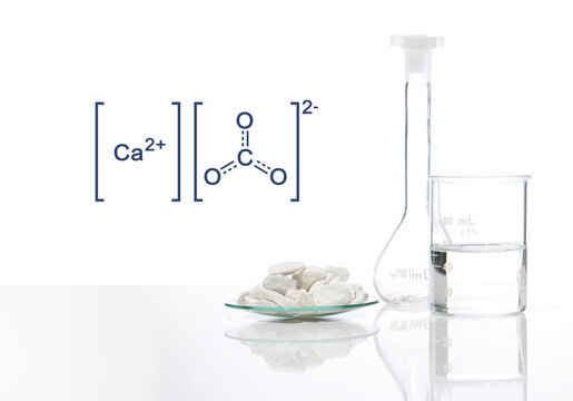 Calcium carbonate chip in chemical watch glass with molecular structure on white laboratory table. Side view