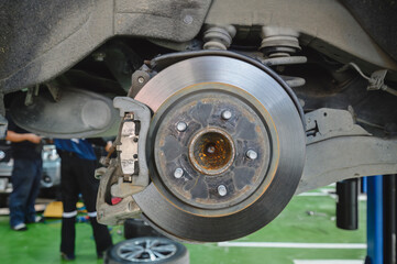 Car rear brake pads replacement and service in garage shop.