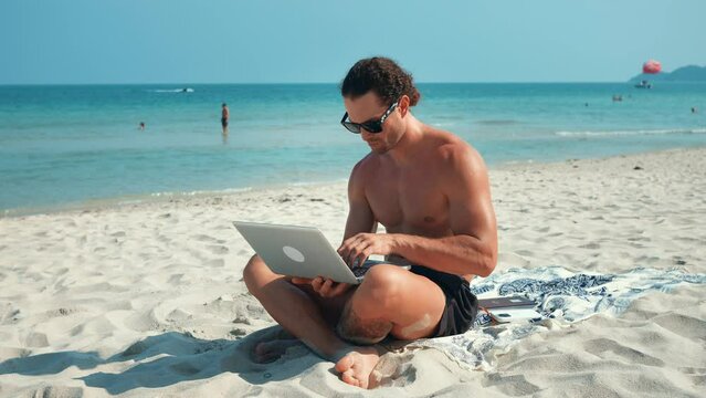 Writer writes book using laptop and is inspired by views island on beach ocean. Island becomes source inspiration, giving ideas. Man immerses in creative process against picturesque landscapes island.