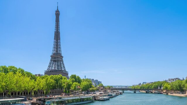 A timelapse of the Eiffel Tower along the river Seine with flyboats passing by with motion blur.Sunny but cloudy spring summer day paris city famous riverside bay tower view bridge timelapse panorama