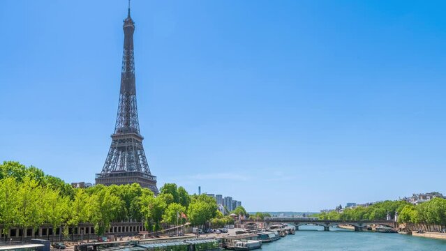 A timelapse of the Eiffel Tower along the river Seine with flyboats passing by with motion blur.Sunny but cloudy spring summer day paris city famous riverside bay tower view bridge timelapse panorama