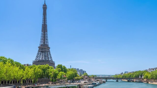 A timelapse of the Eiffel Tower along the river Seine with flyboats passing by with motion blur.Sunny but cloudy spring summer day paris city famous riverside bay tower view bridge timelapse panorama