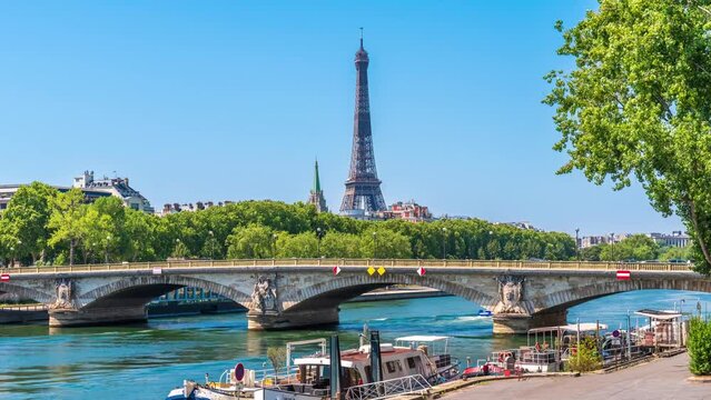 A timelapse of the Eiffel Tower along the river Seine with flyboats passing by with motion blur.Sunny but cloudy spring summer day paris city famous riverside bay tower view bridge timelapse panorama