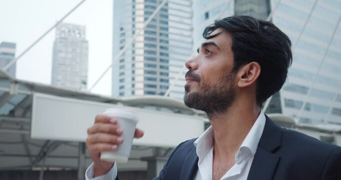 Successful entrepreneur stands in financial district metropolis, drink from coffee cup. Coffee cup during respite from business rhythm city. Coffee cup is essential attribute business person in work.