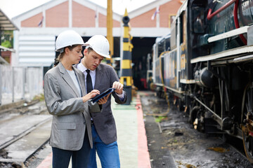 businesspeople talking and checking train on construction site