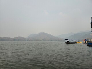 A long-tail boat that is about to depart from a riverside building amidst a beautiful view and...