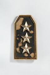 shabby and unkempt three star pin as a badge of rank in the military on a white background