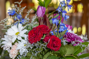 Close up texture background of an indoor florist&rsquo;s bouquet arrangement containing colorful flowers, with defocused background