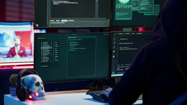 Lone wolf hacker in secret hideout trying to hide online activity after stealing data. Cybercriminal attacking victims PCs using computer virus, trying to avoid being detected, camera A