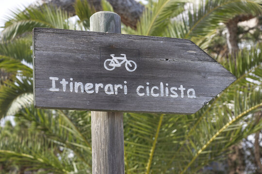 Itinerari Ciclista sign, bicycle route sign in Majorka, Spain with palm trees in the background - leisure and bike holidays.