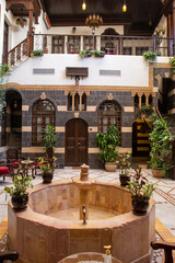 Interior of luxury hotel in oriental style with living plants and fountain in the lobby