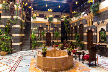 Interior of luxury hotel in oriental style with living plants and fountain in the lobby