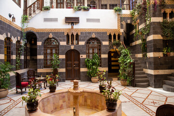 Interior of luxury hotel in oriental style with living plants and fountain in the lobby