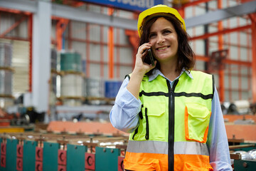 worker or engineer talking about work with coworker on smartphone in the factory