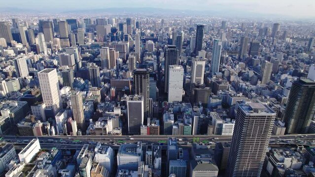 Fly over Osaka Japan, view of trafficked road, skyscrapers and more