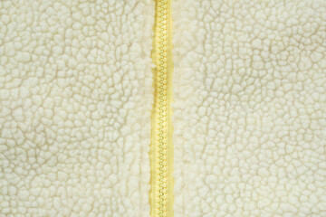 Yellow zipper on wool plush fleece fur fabric texture background