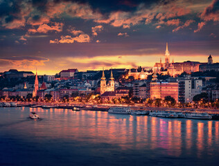 Obraz premium Dramatic evening view of Inner City parish Church and Fisherman's Bastion in Pest city. Great sunset on Danube river in Budapest, capital of Hungary, Europe. Travel the world..