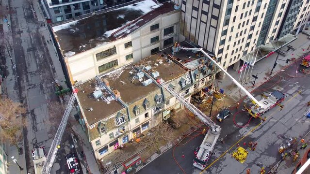 Aerial of Canadian firefighter handling apartment building fire accident in the downtown area in Ville-Marie, Montreal, Quebec, Canada