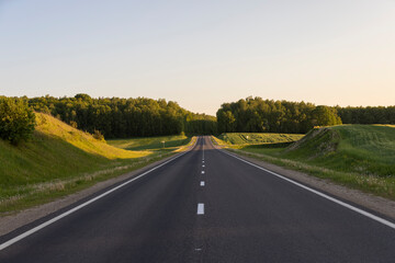 a colored sky at sunset and an empty highway