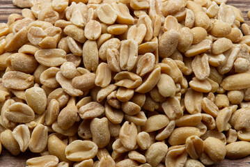 Pealed Peanuts isolated on wooden background. Close-up. Top view.