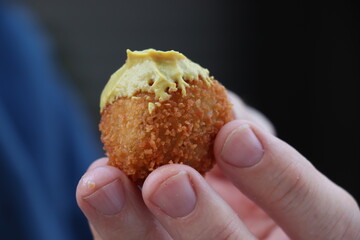 Dutch snack:  Man eating a bitterbal