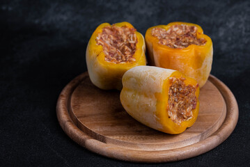Frozen stuffed peppers filled with meat and rice, on dark black background, semi-finished, ready for cooking. Convenience and homemade frozen healthy meals.