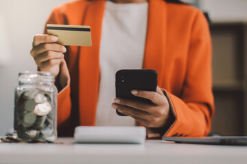 Woman is doing online purchases. Girl is doing shopping using phone and credit card at home.