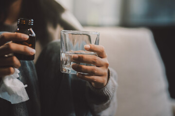 Upset woman frustrated by problem with work or relationships, sitting on couch, embracing knees, covered face in hand, feeling despair and anxiety, loneliness, having psychological trouble