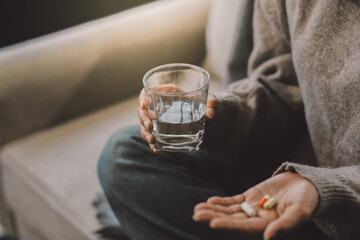 Upset woman frustrated by problem with work or relationships, sitting on couch, embracing knees, covered face in hand, feeling despair and anxiety, loneliness, having psychological trouble