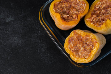 Frozen stuffed peppers filled with meat and rice, on dark black background, semi-finished, ready for cooking. Convenience and homemade frozen healthy meals.