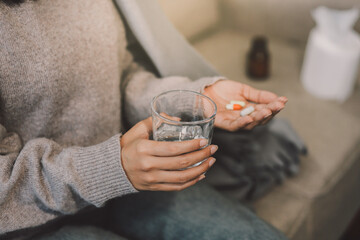 Upset woman frustrated by problem with work or relationships, sitting on couch, embracing knees, covered face in hand, feeling despair and anxiety, loneliness, having psychological trouble