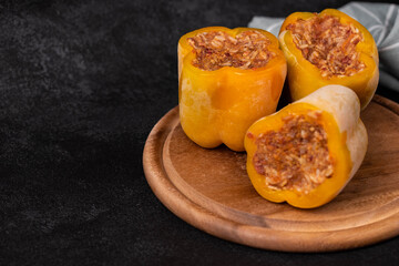 Frozen stuffed peppers filled with meat and rice, on dark black background, semi-finished, ready for cooking. Convenience and homemade frozen healthy meals.