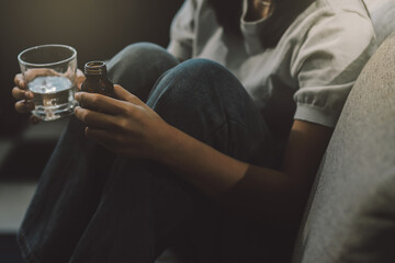 Upset woman frustrated by problem with work or relationships, sitting on couch, embracing knees, covered face in hand, feeling despair and anxiety, loneliness, having psychological trouble