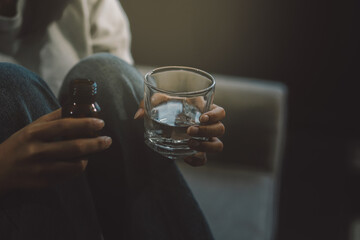 Upset woman frustrated by problem with work or relationships, sitting on couch, embracing knees, covered face in hand, feeling despair and anxiety, loneliness, having psychological trouble