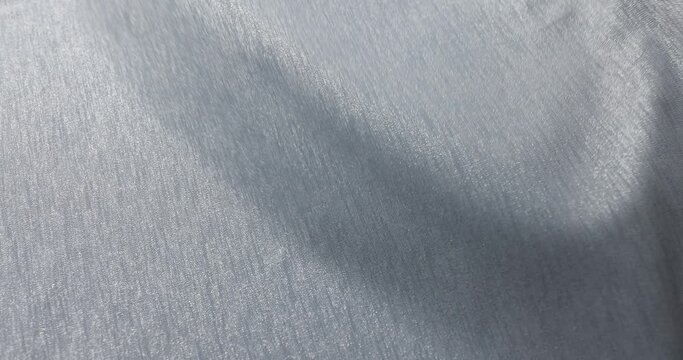 Shiny matte gray fabric surface with a smooth and reflective texture