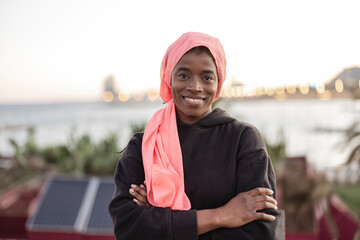 Woman in Hijab Smiling by the Seaside at Dusk