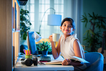 Indian asian girl child having milk while studying at home