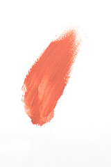 Peach lipstick or blush smear stroke on white background, abstract cosmetic make up sample