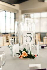 Table centerpiece with candles, flowers, and a table number card