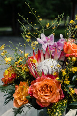Bouquet og orange roses, pink orchids, and yellow flowers