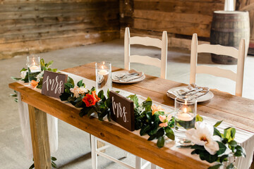 Rustic sweetheart table with floral garland and candles