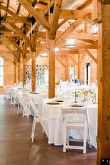 Rustic wedding reception with white tables and chairs