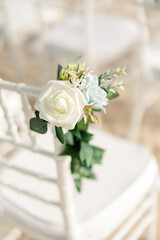 Elegant white and pastel floral bouquet on a white chair