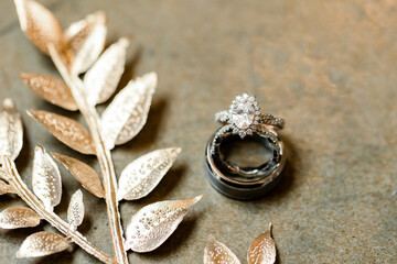 Wedding rings and silver leaves on stone
