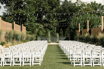 Outdoor wedding setup with chairs and lights