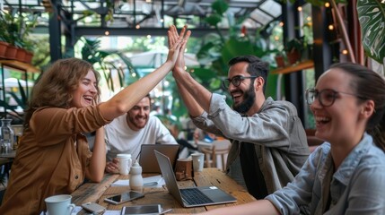 A group of four business professionals celebrating a successful meeting with a high-five. AIG535