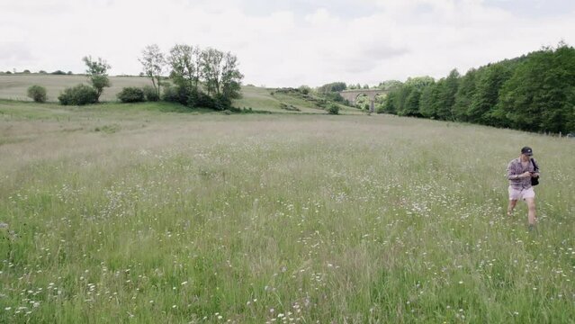 Man With Backpack Running On The Countryside Spring Fields
