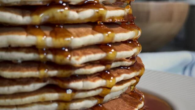 Maple syrup drips off the pancakes
