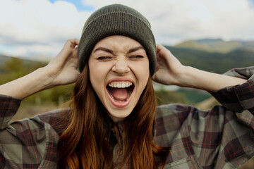 Stylish woman in plaid shirt and beanie covering her ears in a fashionforward outdoor setting